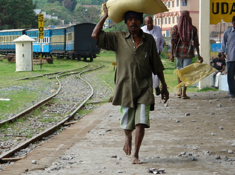 Locals in India walking barefooted at the train station., India