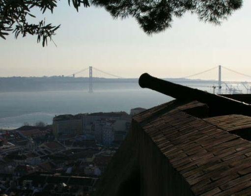 Old canon in Lisbon with a view of the Lisbon Bridge , Portugal